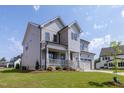 Inviting two-story home featuring a charming front porch and manicured lawn in a suburban neighborhood at 3521 Amelia Grace Dr # 67, Fuquay Varina, NC 27526