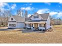 Stunning white farmhouse with a dark roof, covered porch, and attached garage, creating an inviting facade at 3608 Buzzard Rd, Wendell, NC 27591