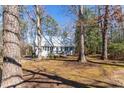 The cottage-style home is surrounded by trees with a mossy yard at 365 Shawnee Dr, Louisburg, NC 27549