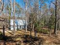 A cottage-style home nestled amongst the trees, accessible by a gravel driveway at 365 Shawnee Dr, Louisburg, NC 27549