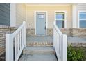 Inviting covered front porch with brick accents and steps leading to the light blue front door at 3725 Rosebush Dr, Zebulon, NC 27597