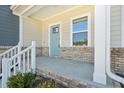 Inviting covered front porch with brick accents and steps leading to the light blue front door at 3725 Rosebush Dr, Zebulon, NC 27597