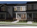 New townhome with gray siding, brick foundation, and covered front porch at 3727 Rosebush Dr, Zebulon, NC 27597