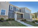 Two-story townhome with blue siding, brick accents and a covered front porch at 3727 Rosebush Dr, Zebulon, NC 27597