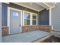 Inviting front porch with brick accents and covered entry at 3727 Rosebush Dr, Zebulon, NC 27597