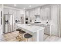 Modern kitchen with stainless steel appliances, grey cabinets, a central island with seating, and white subway tile backsplash at 3813 Rosebush Dr, Zebulon, NC 27597