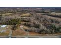 Expansive aerial shot showcasing the home's secluded location amidst lush trees and open fields at 3817 Nc-119, Mebane, NC 27302