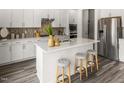 Modern kitchen featuring white cabinets, stainless steel appliances, and a large center island with seating at 3817 Rosebush Dr, Zebulon, NC 27597