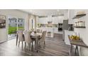 Open-concept kitchen with white cabinets, stainless appliances, and a dining area with sliding glass doors at 3817 Rosebush Dr, Zebulon, NC 27597