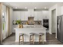 Bright kitchen featuring white cabinets, a center island with seating, and stainless steel appliances at 3817 Rosebush Dr, Zebulon, NC 27597