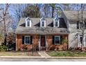 Attractive brick home featuring dormer windows, black shutters, and a manicured lawn at 748 Weathergreen Dr, Raleigh, NC 27615