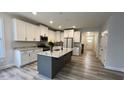 Spacious kitchen with an island featuring granite countertops and stylish white cabinetry at 1013 Greatland Road, Durham, NC 27703