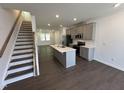 Open-concept kitchen featuring gray cabinets, stainless steel appliances, and large island at 1551 Crescent Townes Way, Raleigh, NC 27604