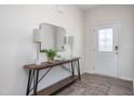 A bright entryway featuring a decorative front door, stylish console table, mirror, lamps, rug and wood flooring at 1752 Post Oak Dr, Haw River, NC 27258
