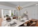 Bright dining room featuring a marble table, chandelier, and an open view to the living room at 200 Indian Elm Ln, Cary, NC 27519