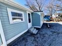 View of house with light blue siding featuring a back door and three concrete steps at 212 Craig Ave, Henderson, NC 27537