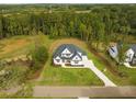 Expansive aerial view of a luxurious property surrounded by lush greenery and mature trees at 2325 Ballywater Lea Way, Wake Forest, NC 27587