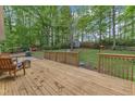 A spacious wood deck overlooks a serene backyard with mature trees and grassy area, perfect for entertaining at 2409 Parkway Dr, Raleigh, NC 27603