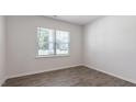 Bright bedroom featuring wood-look floors, neutral walls, and large window at 261 Hawksmoore Ln, Lillington, NC 27546