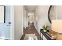 Hallway with light walls, wood floors, decorative mirror and an entry to an office at 269 Hawksmoore Ln, Lillington, NC 27546