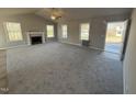 Bright living room featuring a cozy fireplace, large windows, plush carpeting, and plenty of natural light at 271 Starry Sky Dr, Benson, NC 27504
