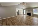 Bright living room featuring wood floors, vaulted ceilings, fireplace, and views into the kitchen at 349 Earnest Way # 21, Kenly, NC 27542