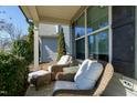 Relaxing front porch featuring comfortable wicker chairs with plush white cushions and a glass-topped table at 3517 Eastern Branch Rd, Raleigh, NC 27610