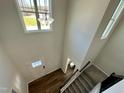 Bright foyer with hardwood floors, staircase, and view of a half bathroom from above at 377 Earnest Way, Kenly, NC 27542