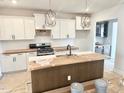 Bright kitchen featuring white cabinets, quartz countertops, tile backsplash, and a center island at 44 Blue Iris Pkwy # 121, Clayton, NC 27520