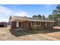 Exterior view of a brick home featuring a covered front porch and well-lit entrance at 4459 N Old Carriage Rd, Rocky Mount, NC 27804