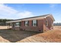 Side view of a red brick home with a covered porch, showcasing the exterior architecture and design at 4459 N Old Carriage Rd, Rocky Mount, NC 27804