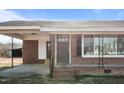 Up close, the brick home features a covered porch and large window at 4459 N Old Carriage Rd, Rocky Mount, NC 27804