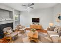 Bright, staged living room with fireplace, ceiling fan, and stylish furnishings at 4820 Landover Arbor Pl, Raleigh, NC 27616