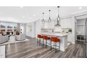 Stylish open-concept kitchen with white cabinets, island seating, and stainless steel appliances at 625 Emerald Bay Cir, Raleigh, NC 27610