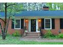 Inviting front entrance with brick steps, decorative lights, and a charming wreath at 711 Stuart Dr, Sanford, NC 27330