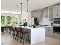 Bright kitchen featuring an island with seating, stainless appliances, and light wood floors at 806 Hyperion Aly, Wake Forest, NC 27587