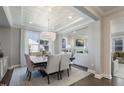 Formal dining room boasts a unique tray ceiling, modern chandelier, and large windows for natural light at 812 Emerald Bay Cir, Raleigh, NC 27610