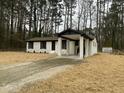 Renovated brick home featuring a welcoming covered drive-through, surrounded by a natural wooded landscape at 905 Spruce Pine Trl, Durham, NC 27705