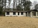 Inviting renovated brick home with a charming covered drive-through, set against a backdrop of mature trees at 905 Spruce Pine Trl, Durham, NC 27705