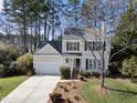 Charming two-story home with light yellow siding, green shutters, a front yard, and an attached one-car garage at 102 Ashley Brook Ct, Cary, NC 27513