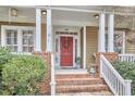 Inviting front porch featuring brick accents, ceiling fans, and well-maintained landscaping at 102 Westside Dr, Chapel Hill, NC 27516