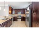View of kitchen featuring stainless steel appliances, granite countertops, and dark wood cabinets at 10321 Sablewood Dr # 108, Raleigh, NC 27617
