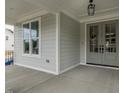 Spacious covered porch featuring a stylish front door and a view of the home's light-colored siding at 104 Bearwallow Forest Way, Wendell, NC 27591