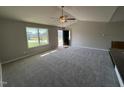 Bright living room featuring plush carpeting, a ceiling fan, and a large window at 107 Faucette Dr, Selma, NC 27576