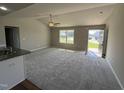 Bright living room featuring plush carpeting, a ceiling fan, and a large window at 107 Faucette Dr, Selma, NC 27576
