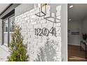 A detailed view of the house number on a white brick exterior with black trim at 1204 Donphil Rd, Durham, NC 27712
