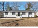 Charming white brick home with black trim, manicured landscaping, and a welcoming entrance at 1204 Donphil Rd, Durham, NC 27712