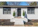 Close-up of a white brick home's front door with manicured shrubs and welcoming entrance at 1204 Donphil Rd, Durham, NC 27712