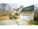 A traditional two-story home with a two-car garage, covered porch, and manicured landscaping at 1226 Woodland Church Rd, Wake Forest, NC 27587