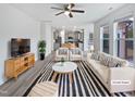 Bright, staged living room with large windows, ceiling fan, modern furniture and an open layout at 1336 Weavers Trace Dr, Zebulon, NC 27597
